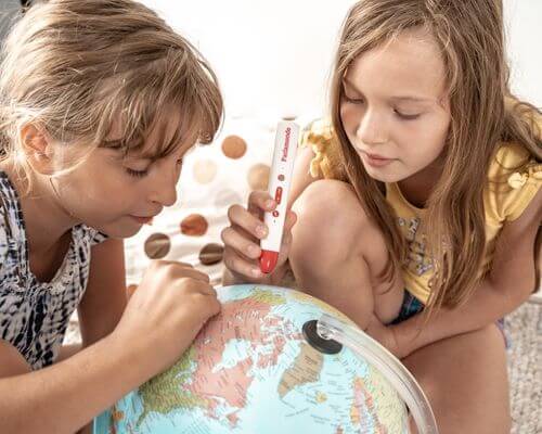 Dziewczynki bawią się globusem interaktywnym Parlamodo ucząc się świata