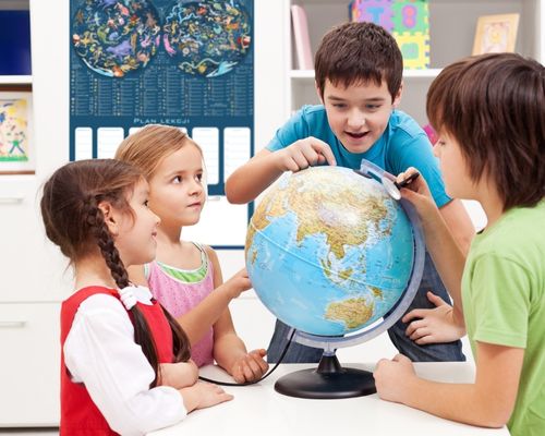 Dzieci podróżują palcem po mapie w pokoju z planem lekcji 